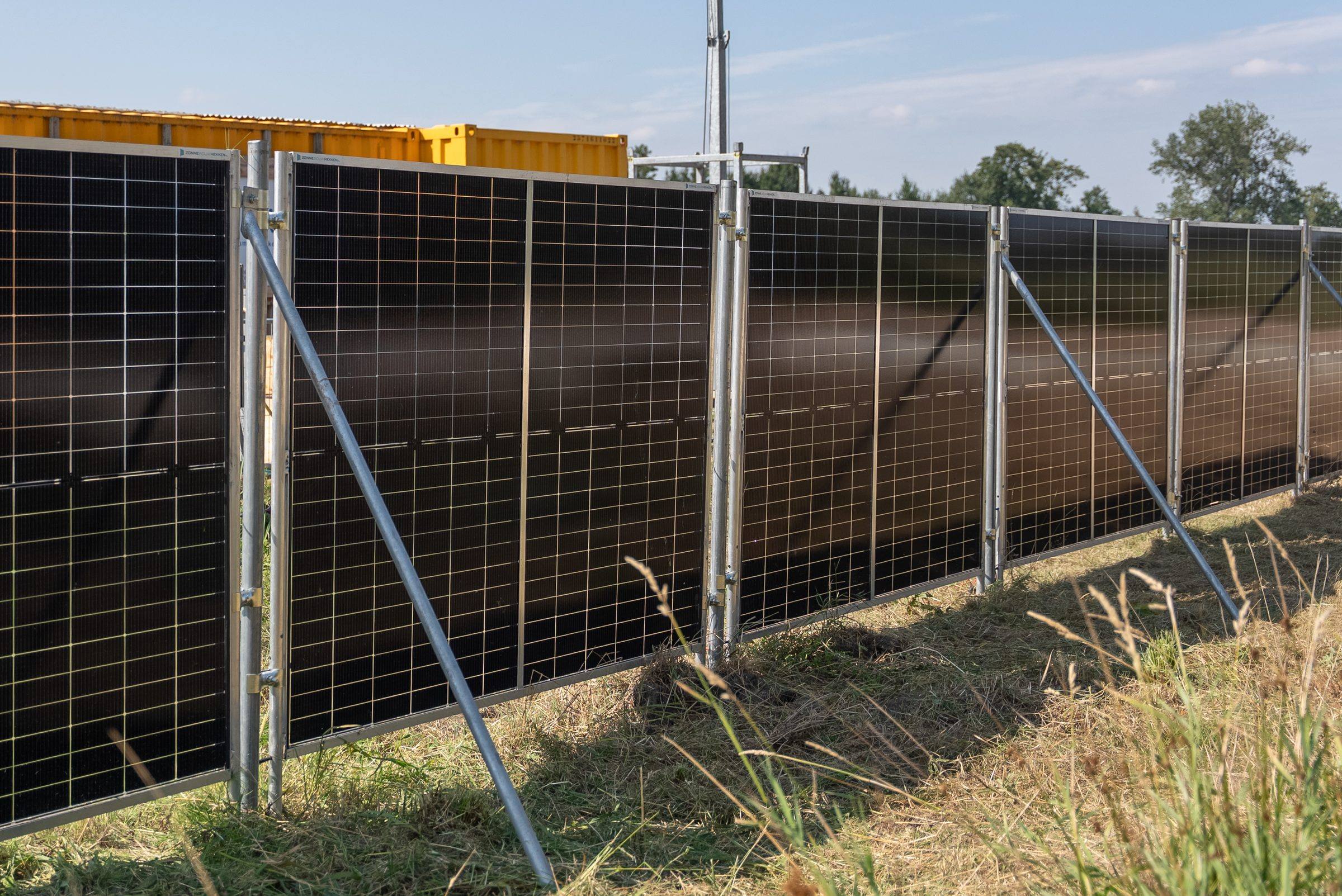 Lange rij zonnebouwhekken met de bus van Green to Grow