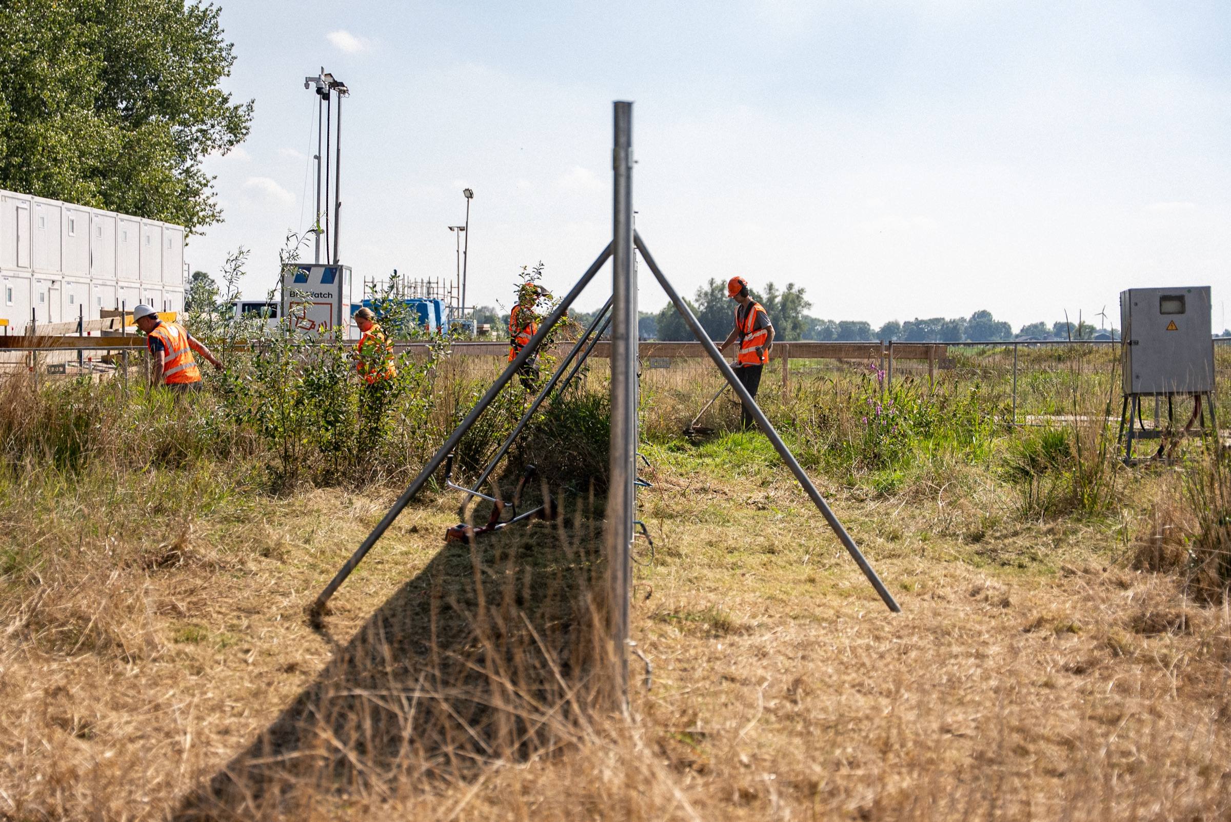 Rij bouwhekken met schoren op een bouwterrein, van dichtbij gezien