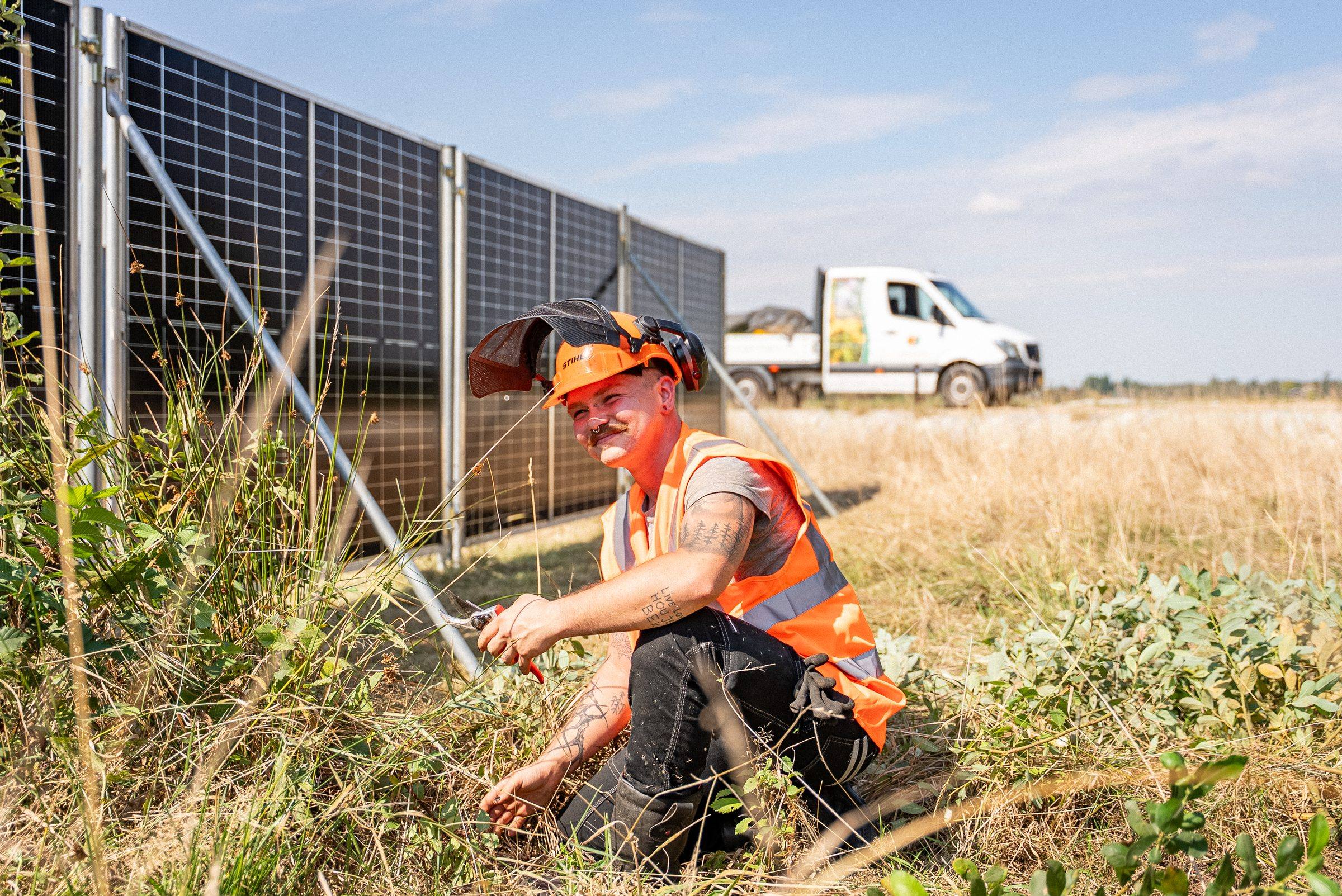 Lachende medewerker van Green to Grow bij de zonnebouwhekken