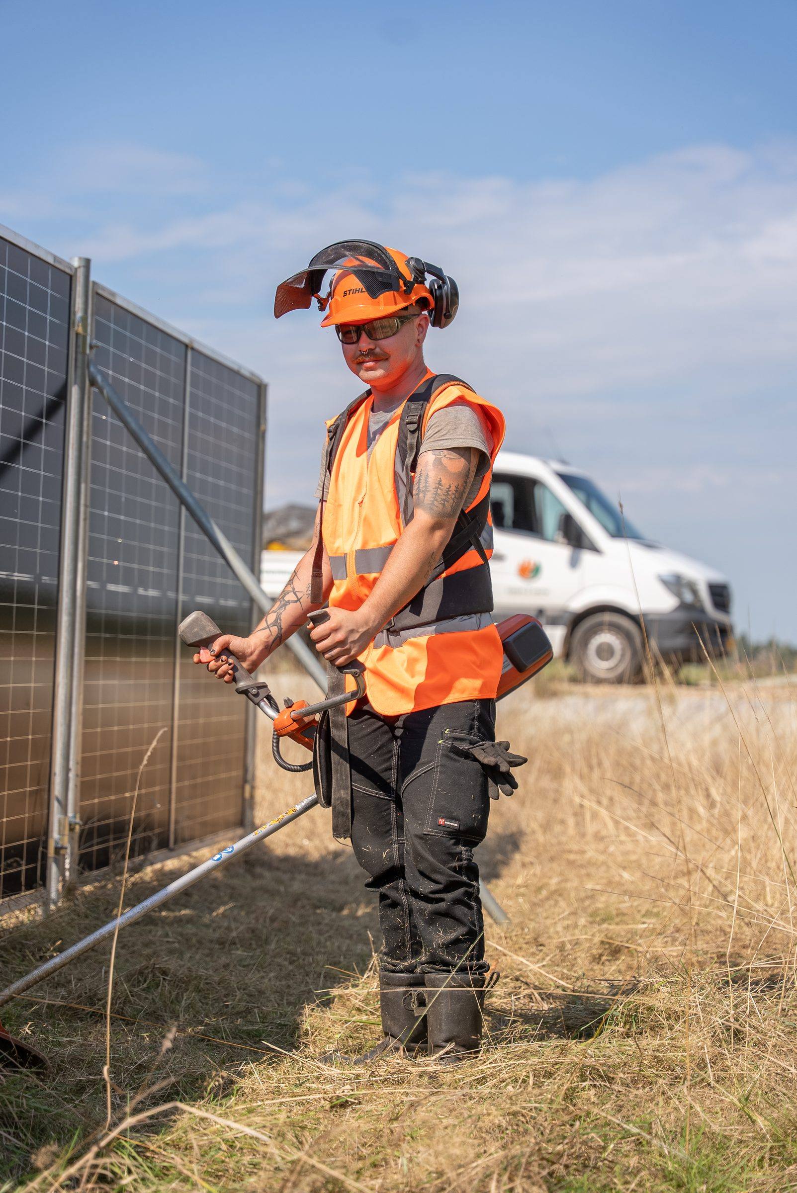 Medewerker van Green to Grow met helm en gehoorbescherming bij de zonnebouwhekken