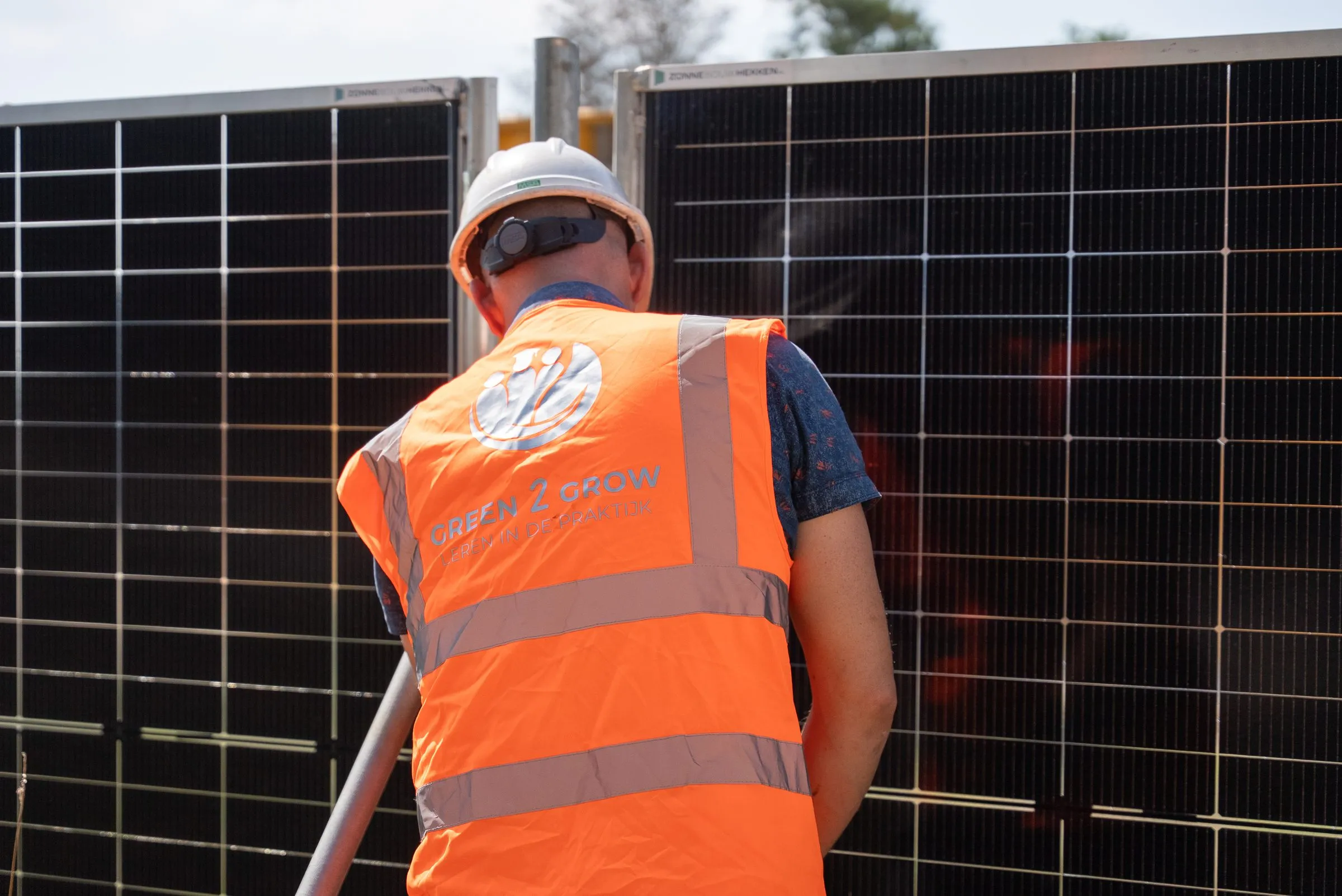 Monteur werkt aan de bevestiging tussen twee zonnebouwhekken