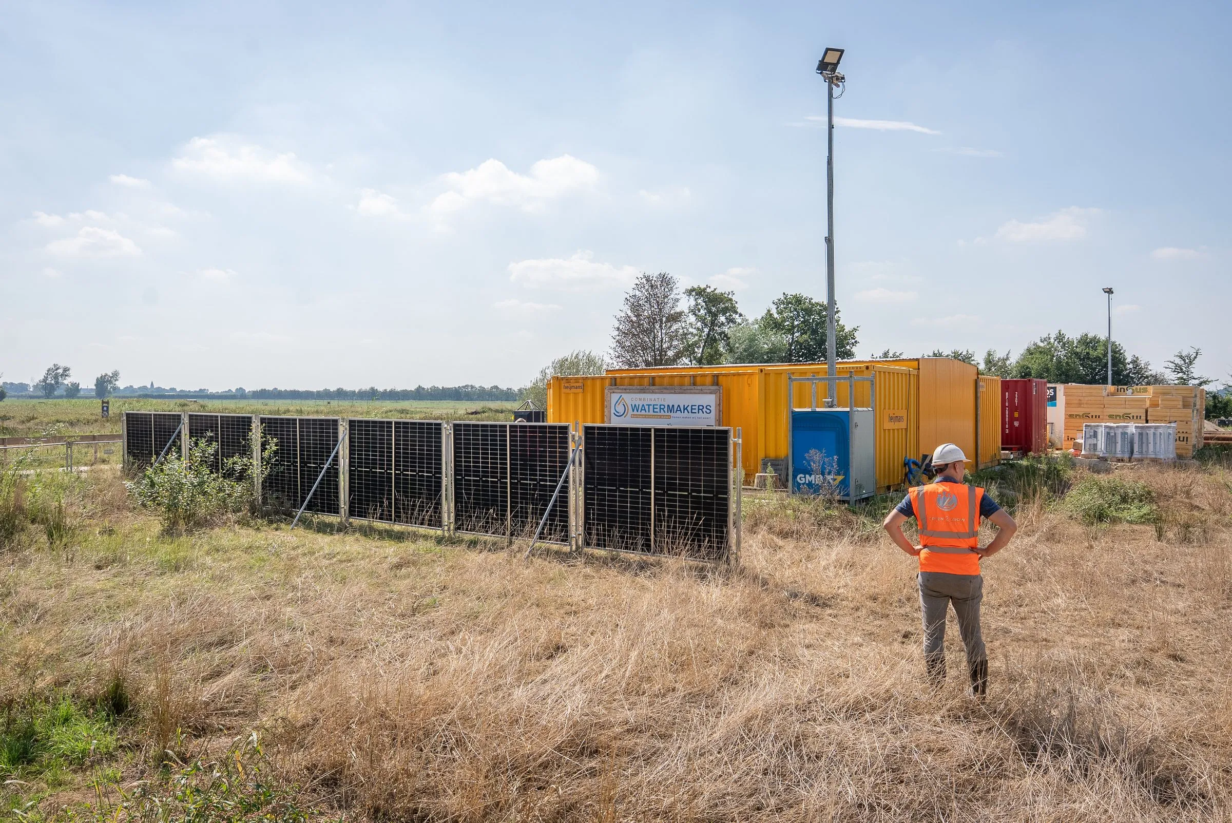 Overzicht van de bouwplaats van Combinatie Watermakers met zonnebouwhekken voor de keten